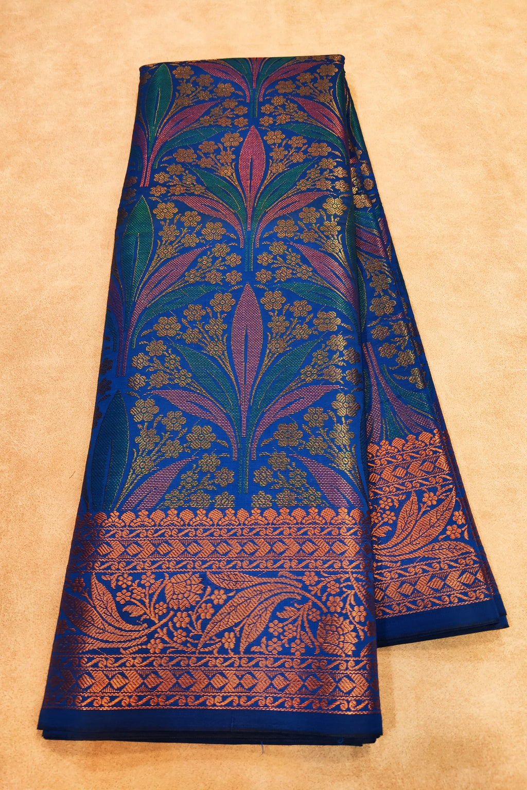 Blue fabric with intricate floral patterns on a beige background