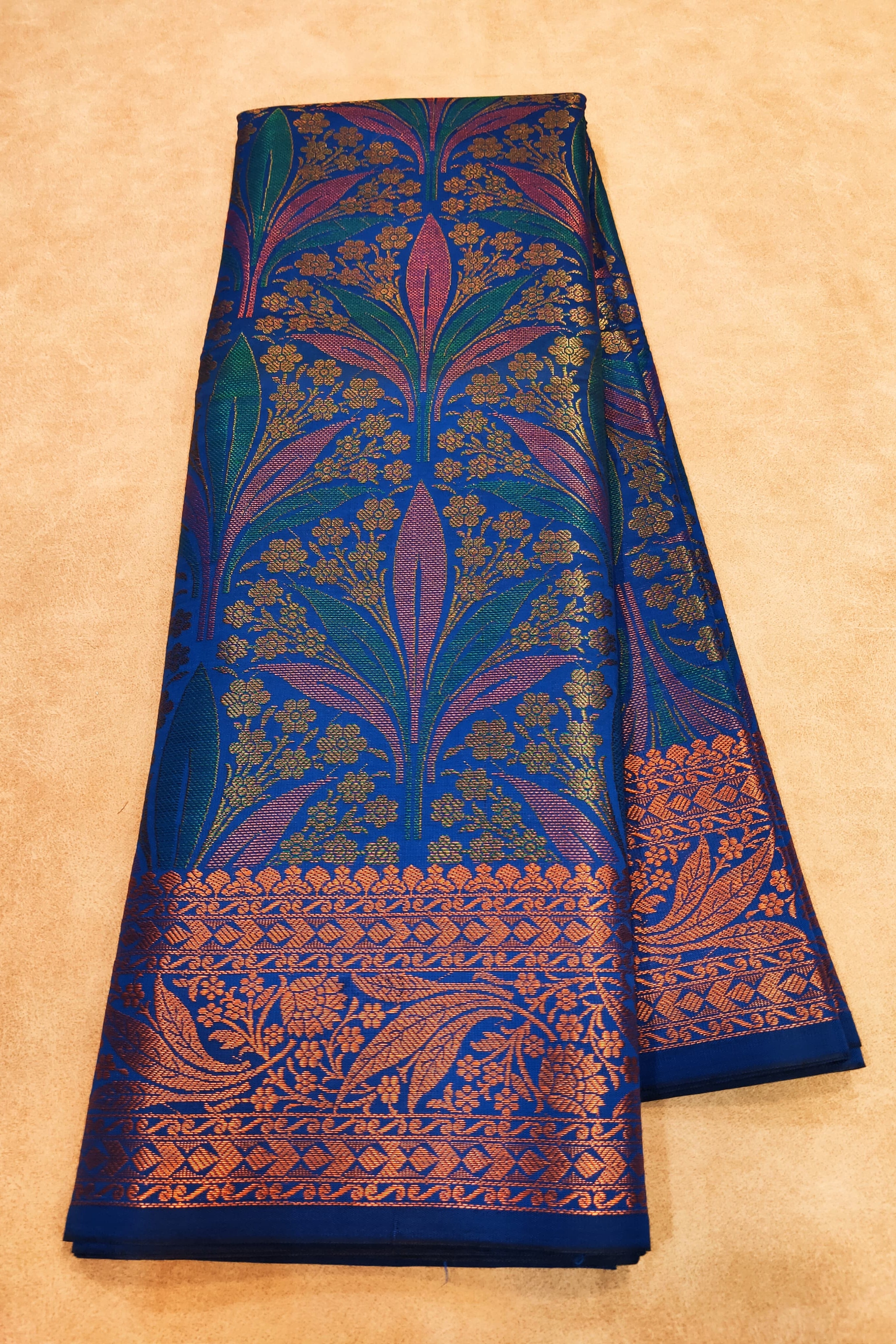 Blue fabric with intricate floral patterns on a beige background