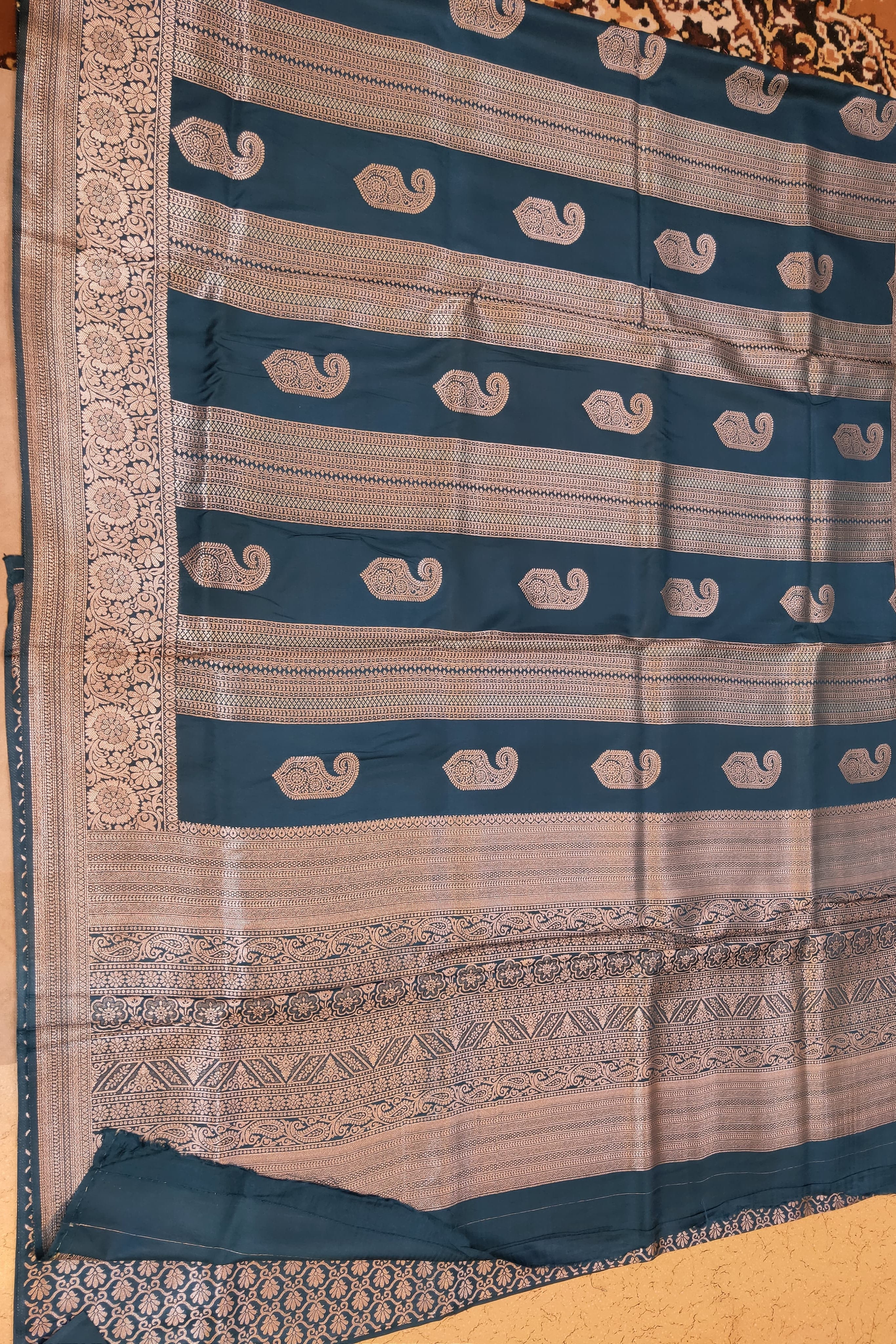 Traditional saree with blue and beige pattern on a wooden surface