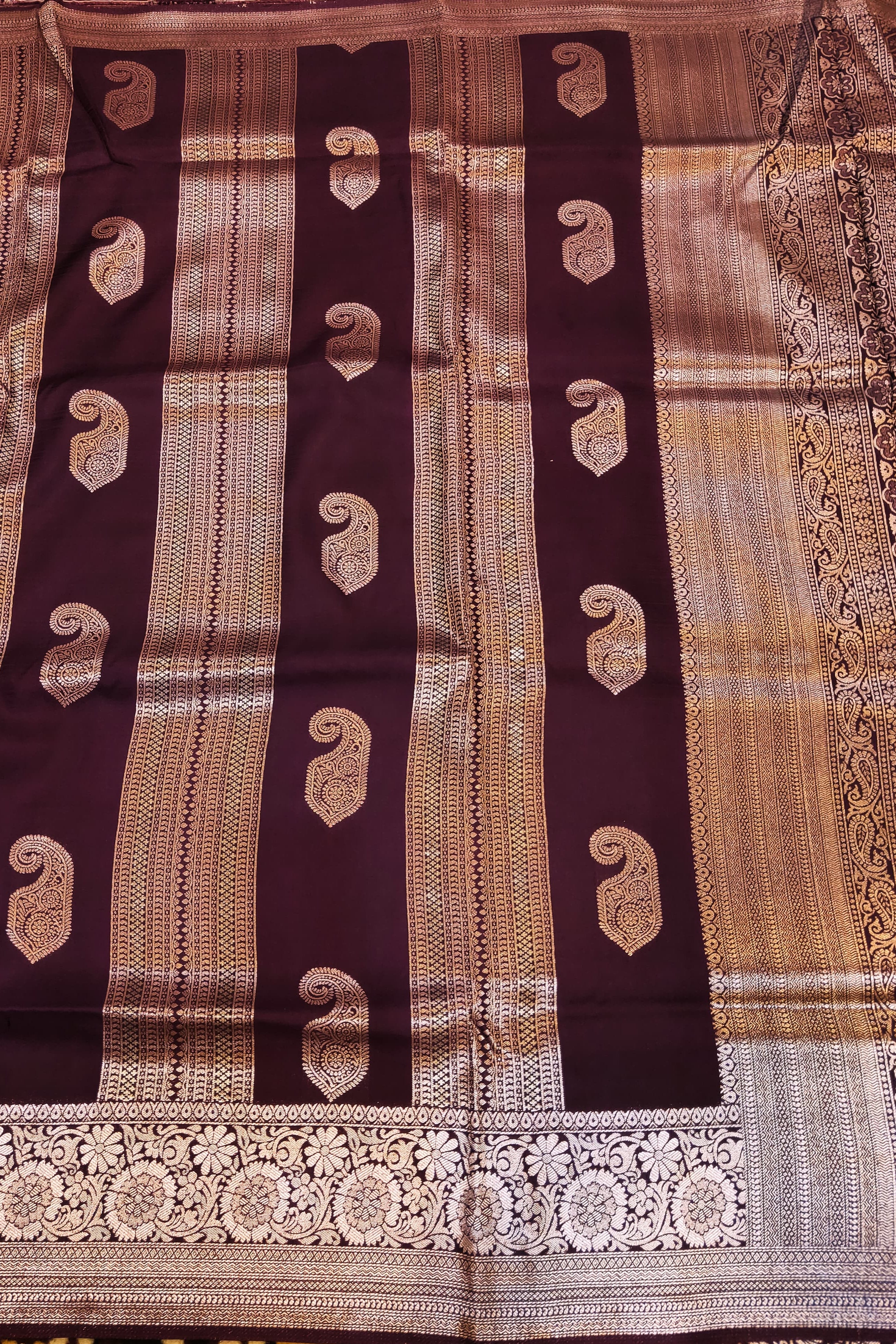 Traditional saree with intricate patterns on a dark brown and beige background