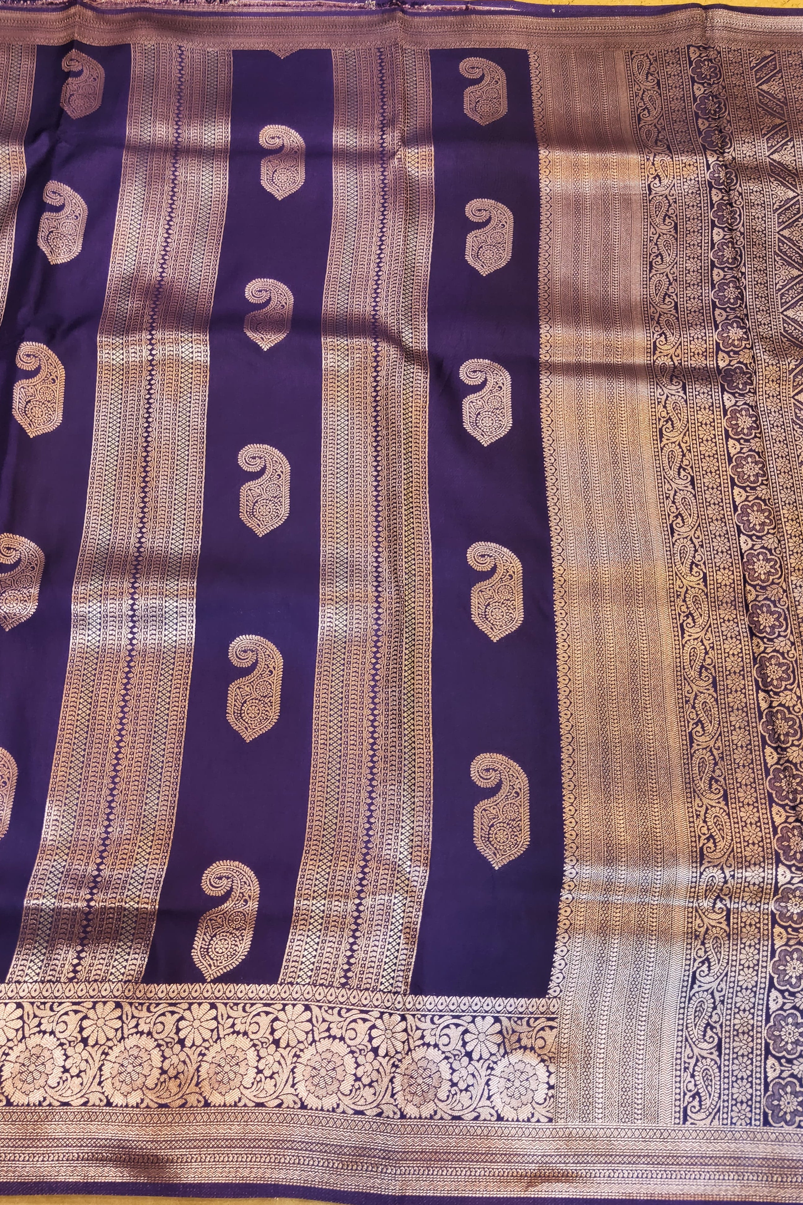 Saree with purple and gold patterns on a yellow background