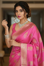 Woman in a pink saree with gold patterns indoors