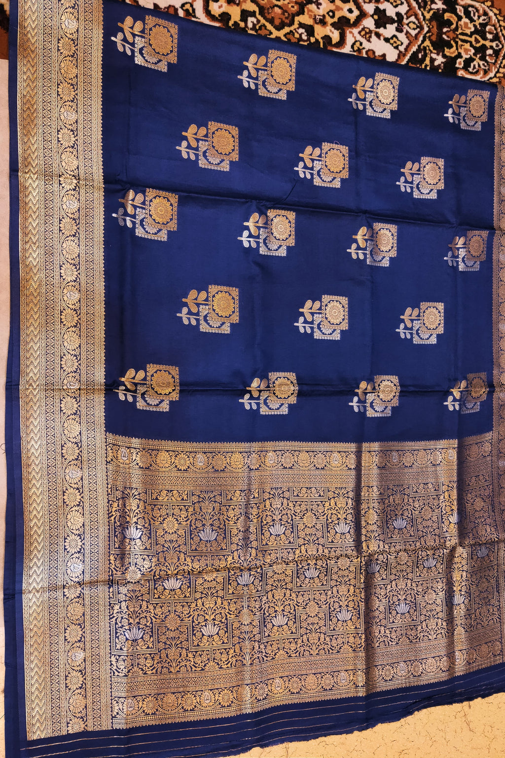 Blue saree with gold patterns on a wooden surface