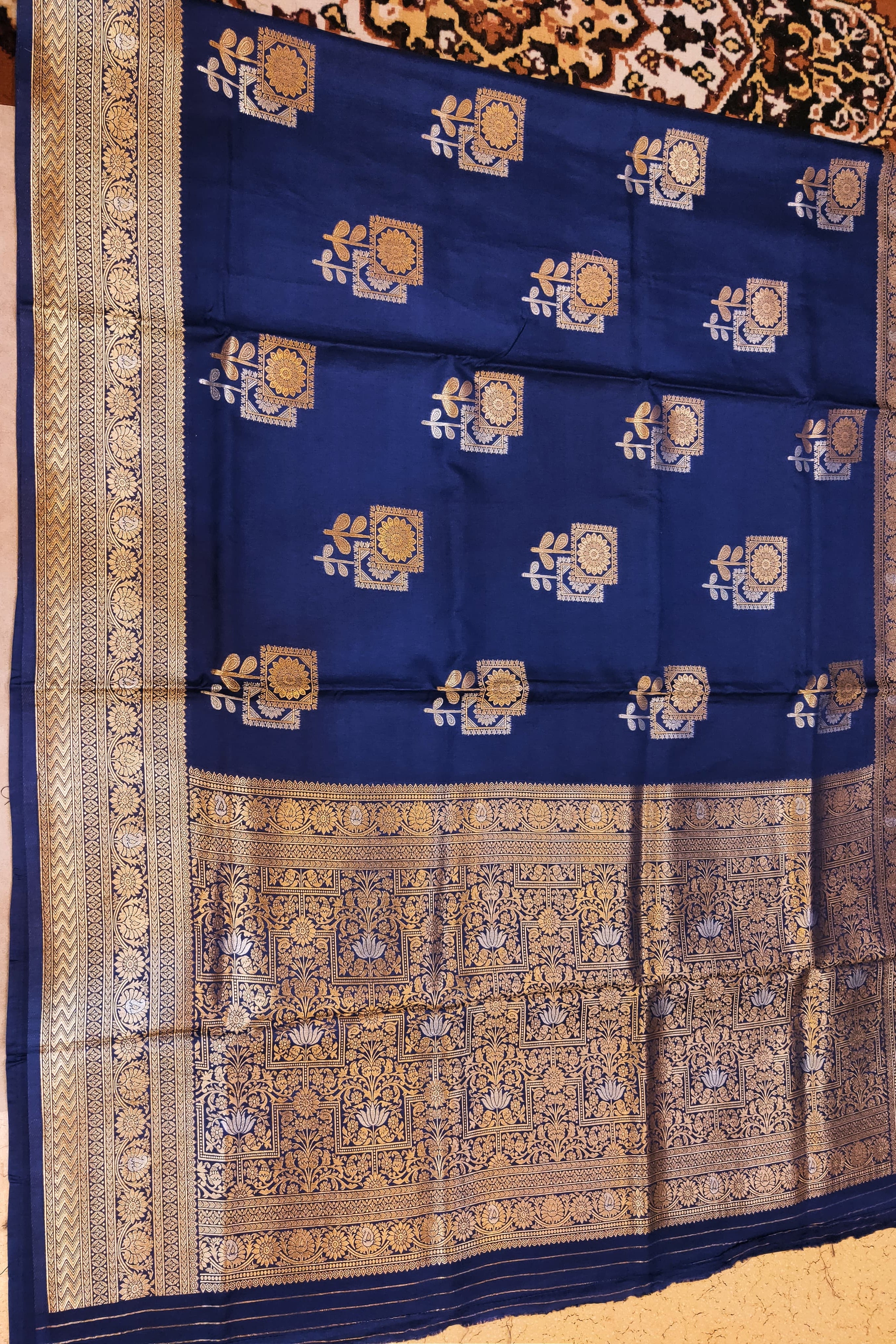 Blue saree with gold patterns on a wooden surface
