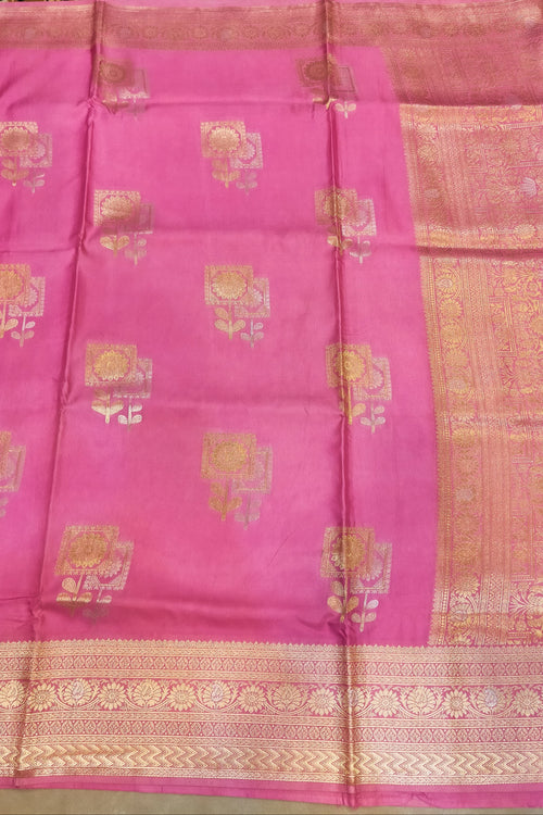 Pink saree with gold patterns on a plain background