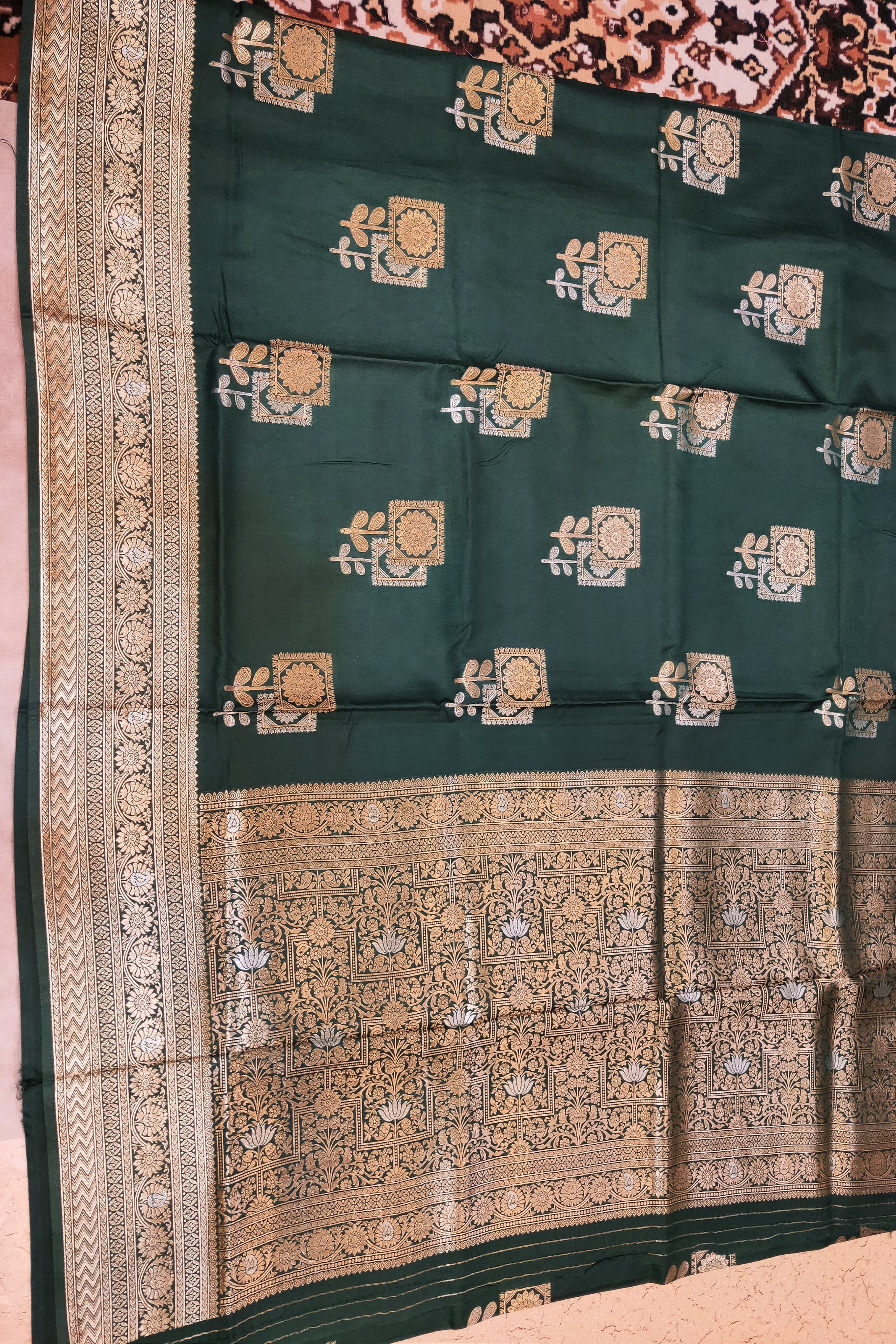 Green saree with intricate patterns on a plain background