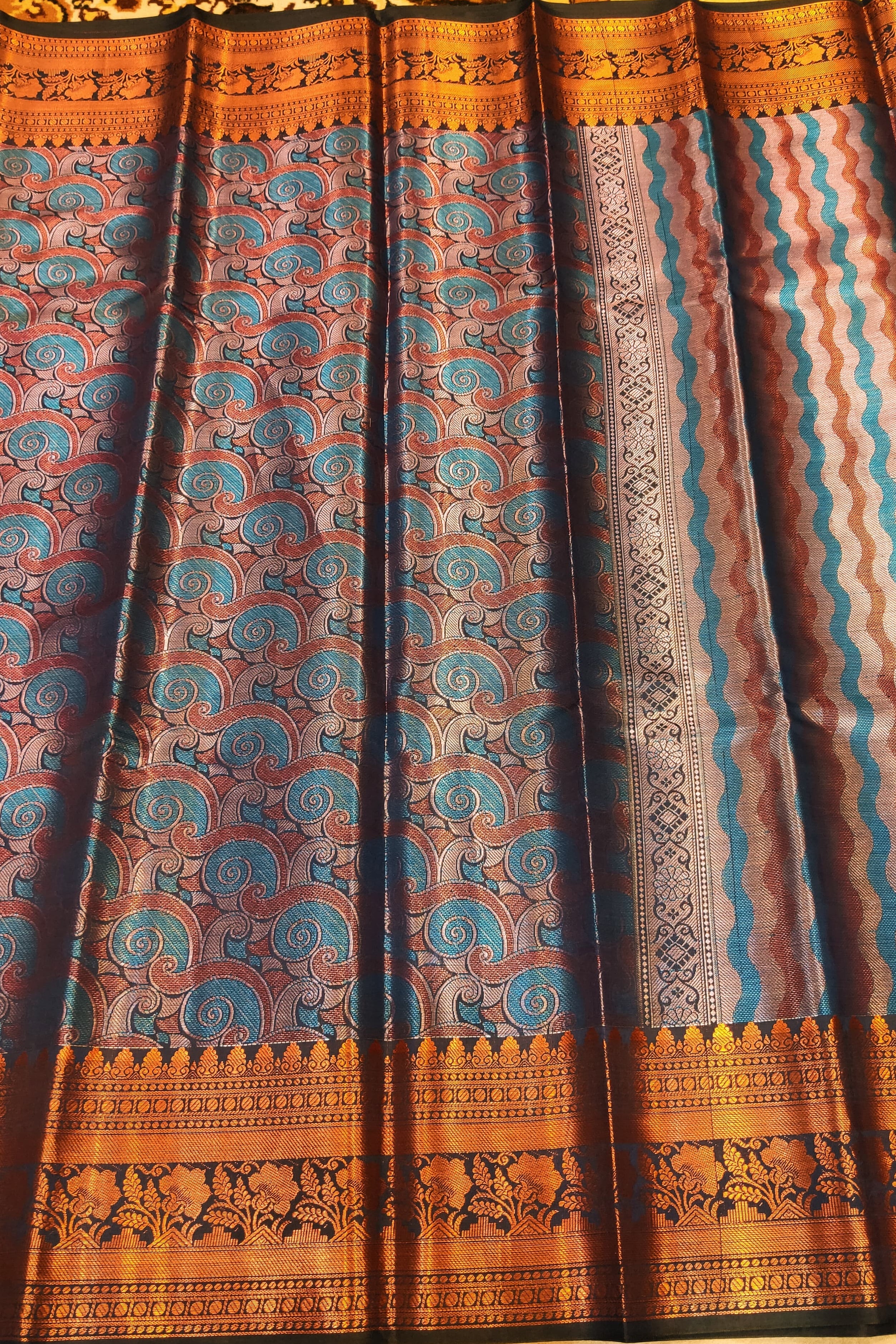 Traditional patterned fabric with blue and brown design on a plain background