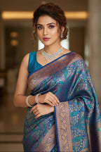 Woman wearing a blue saree with a patterned border indoors