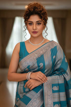 Woman in a blue saree with a blurred indoor background