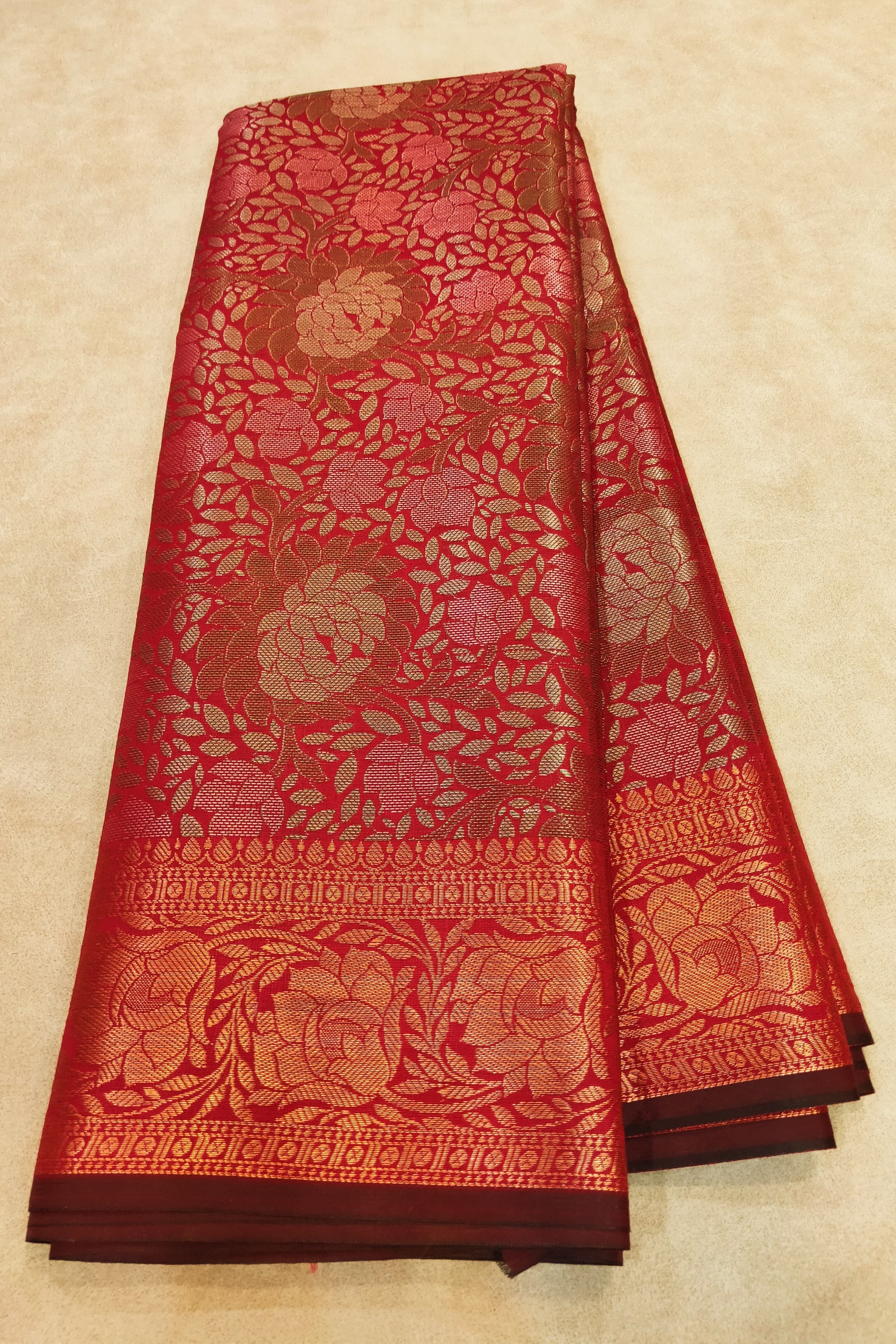 Red and gold patterned fabric on a beige background