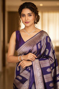 Woman wearing a purple saree with a blurred indoor background