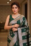 Woman wearing a green saree with silver border indoors