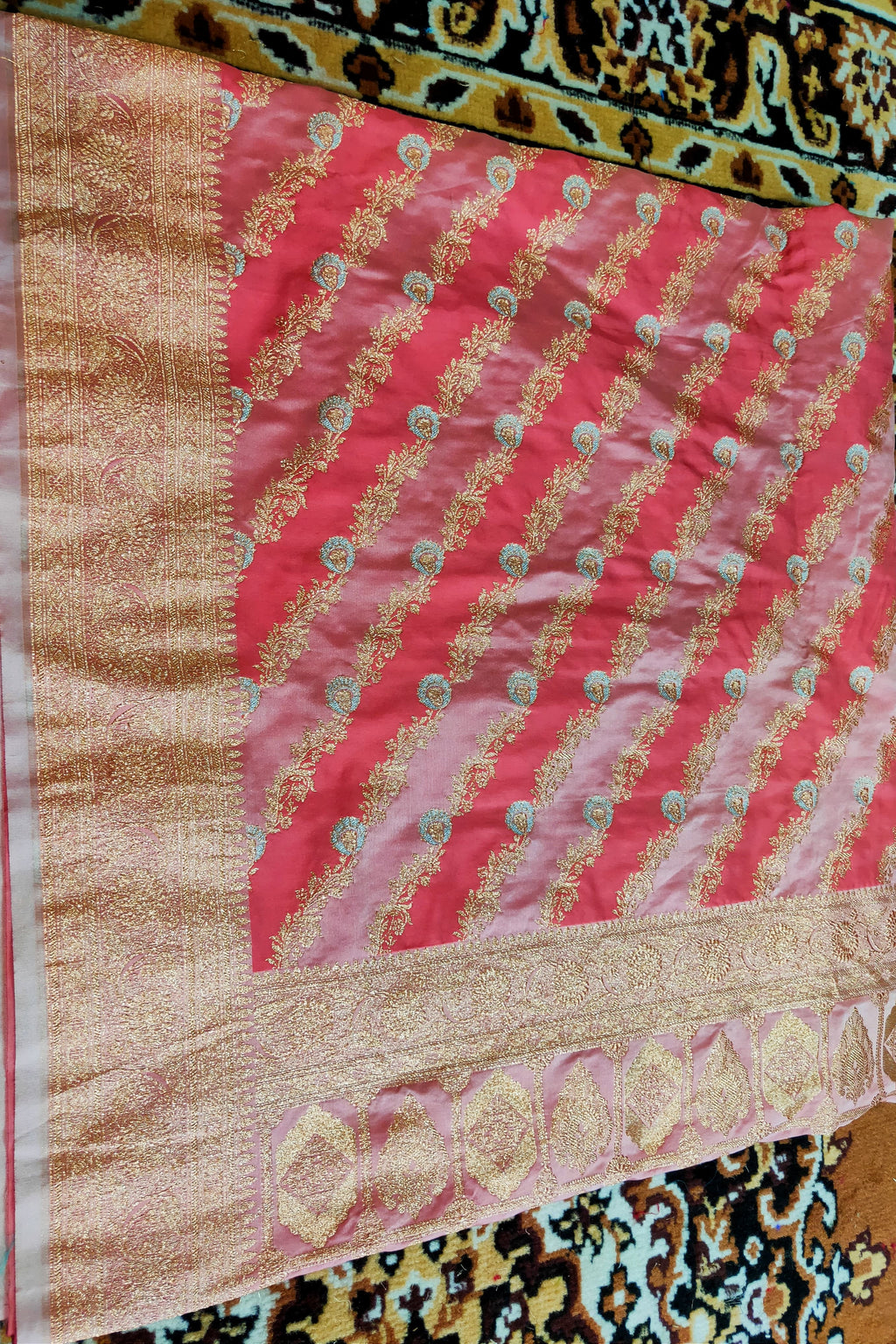 Decorative pink and gold fabric on a patterned surface