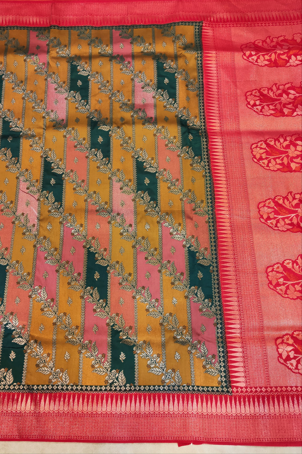 Colorful patterned fabric with a red border on a plain background