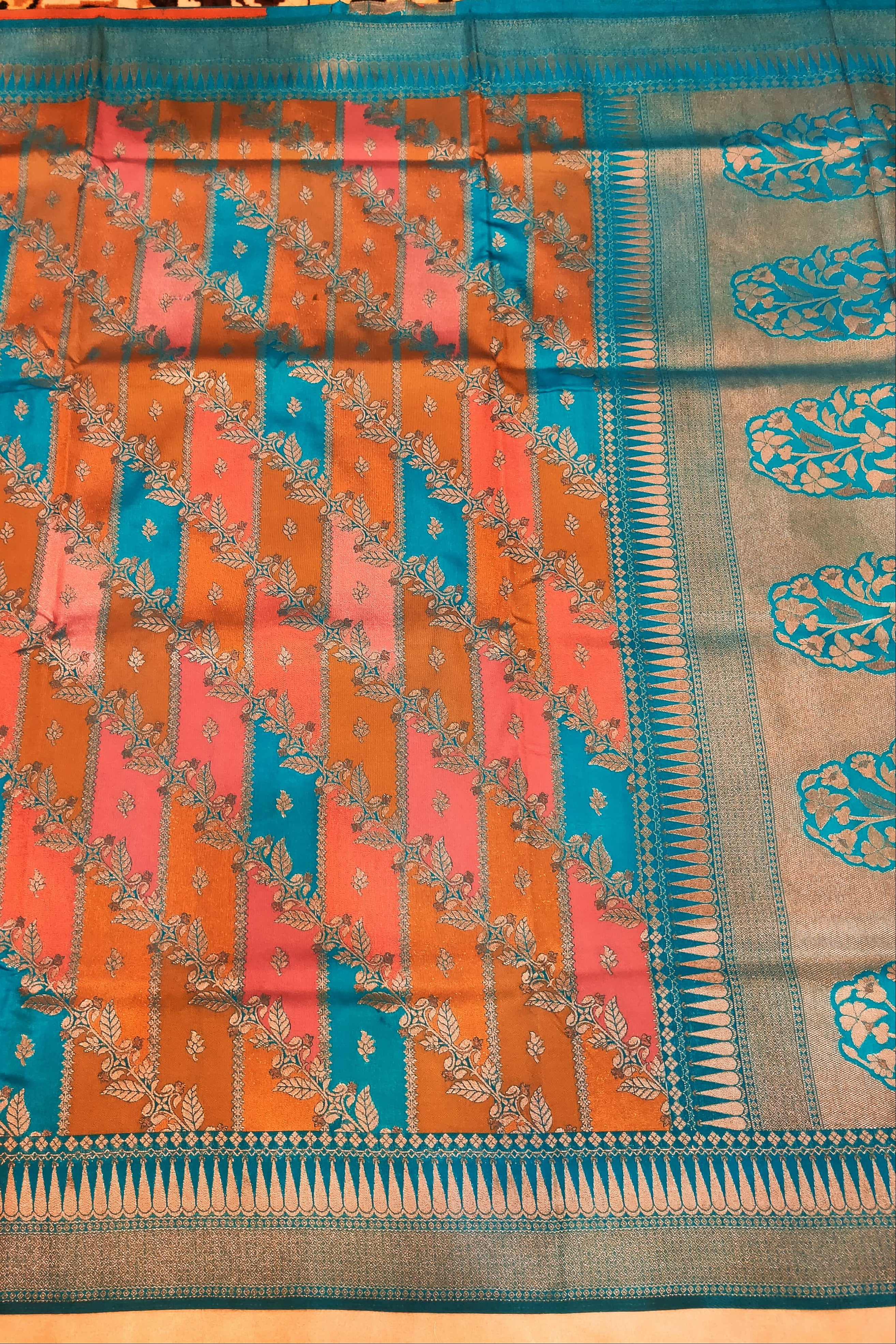 Traditional saree with a blue and orange pattern on a wooden surface