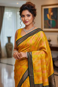 Woman in a yellow saree with a checkered pattern in a room with decor elements.