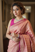 Woman in a pink saree with a blurred indoor background