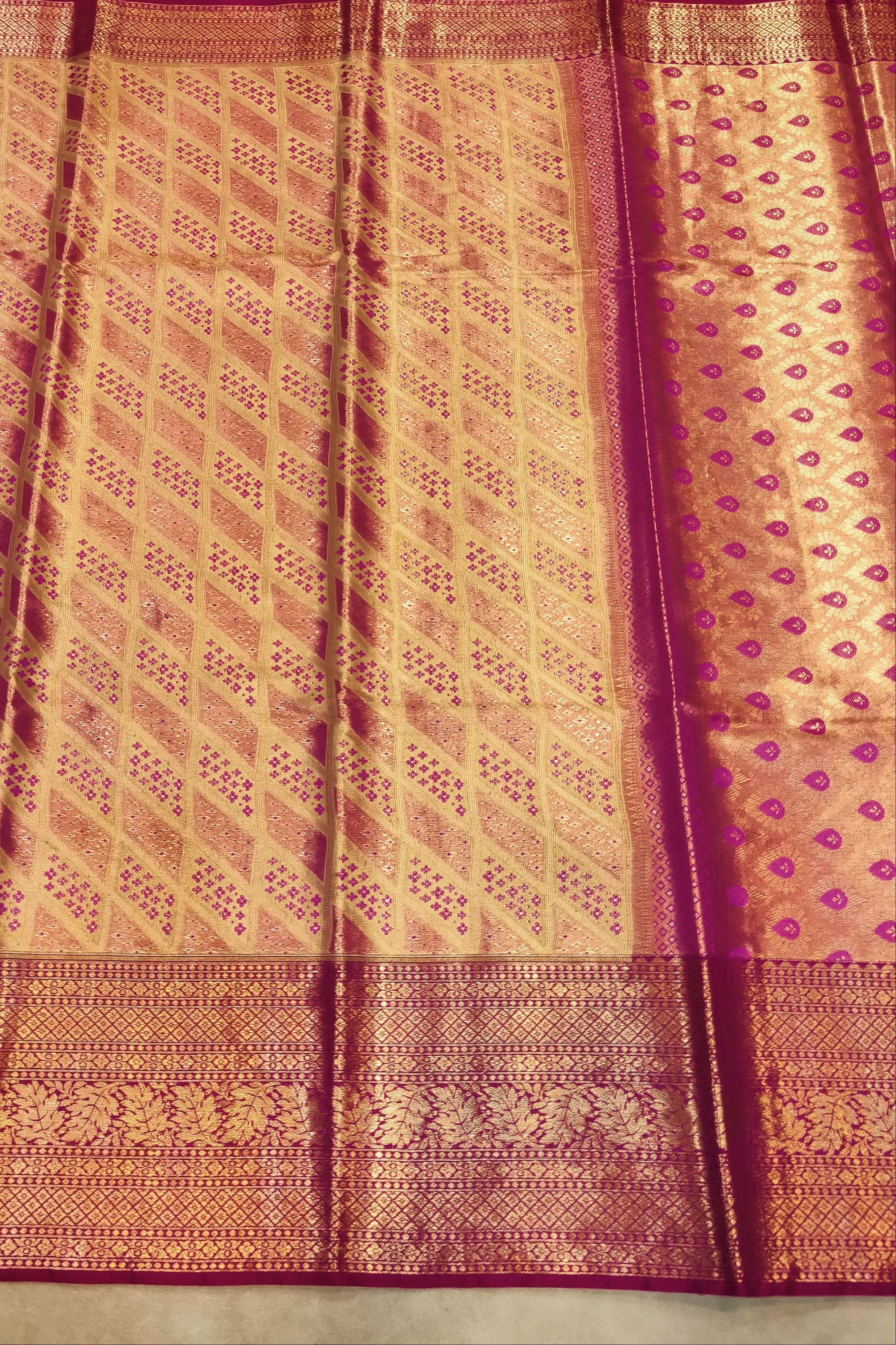 Traditional saree with a pink and gold pattern on a plain background