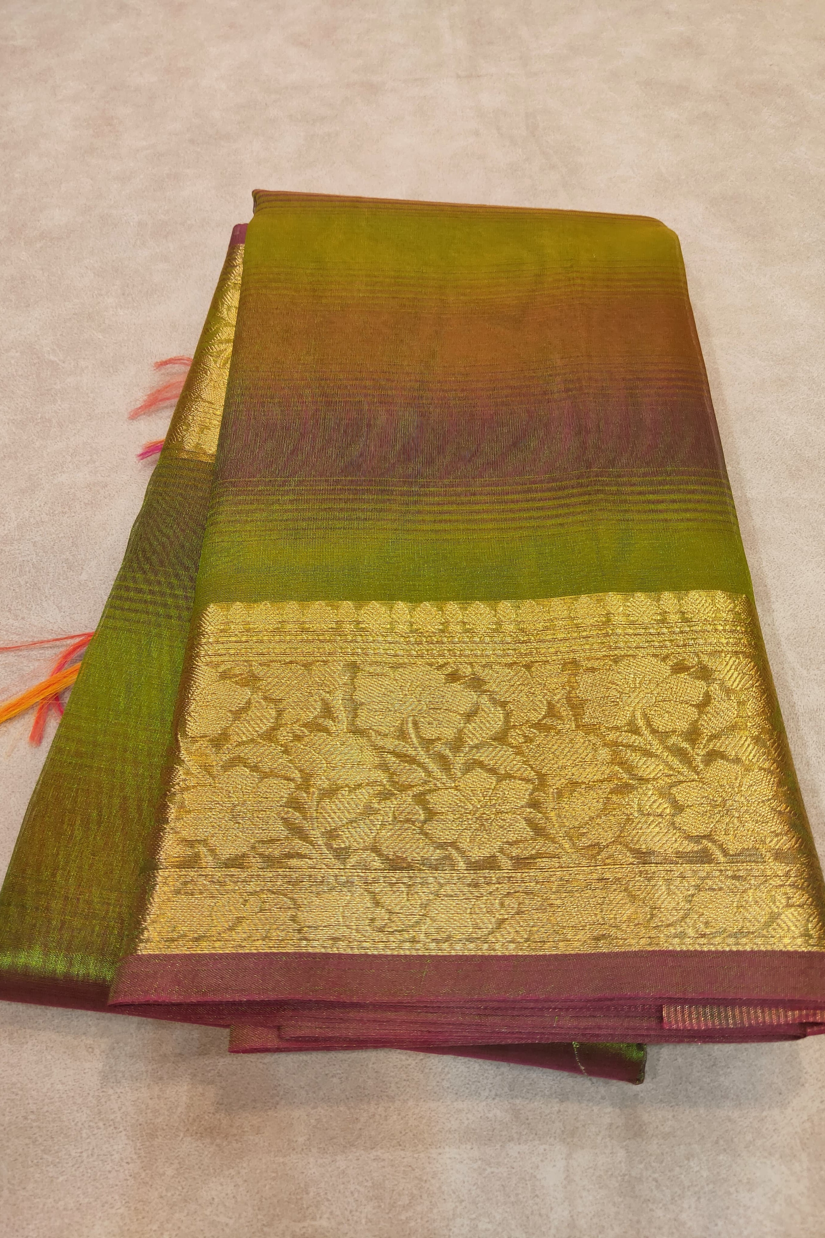 Saree with green and maroon border on a beige background