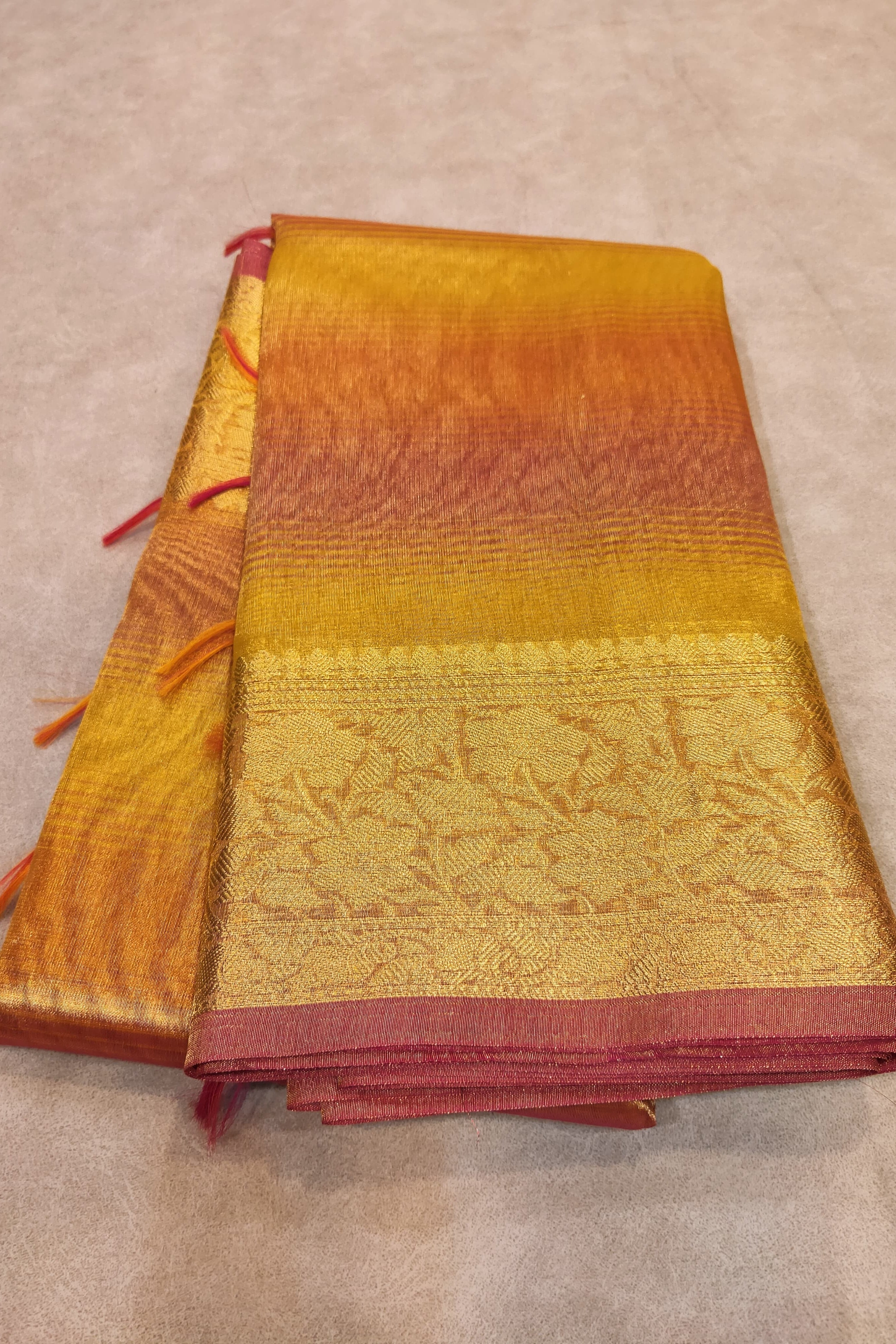 Folded fabric with gradient colors from orange to red on a beige background