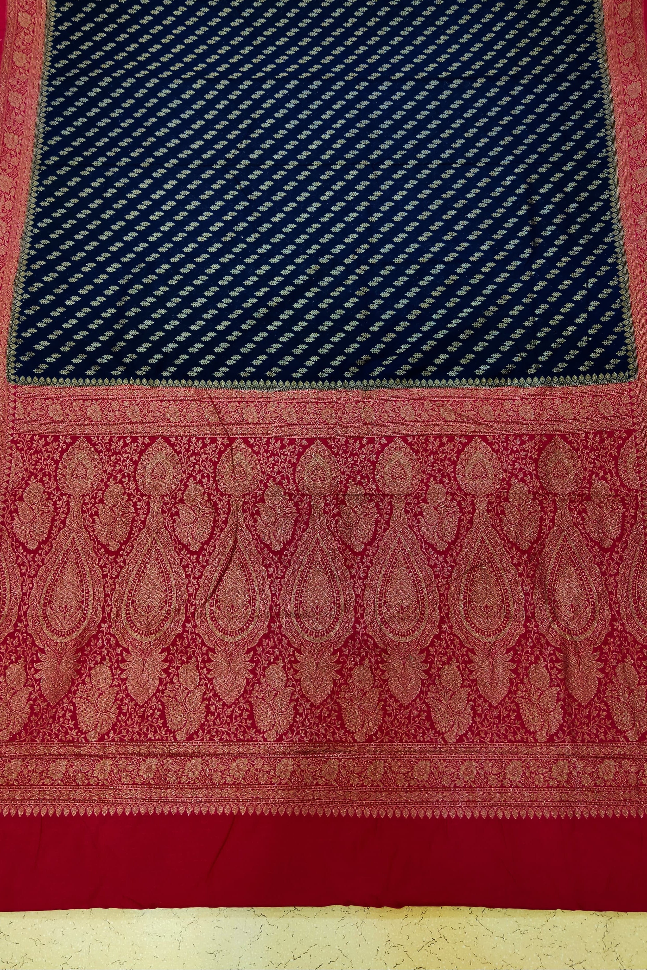 Red and blue patterned fabric on a textured surface