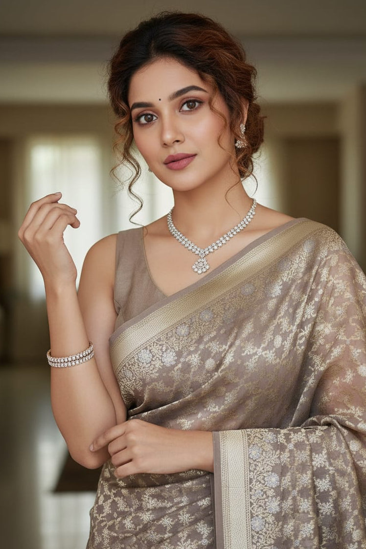 Woman in a saree with jewelry, posing indoors.
