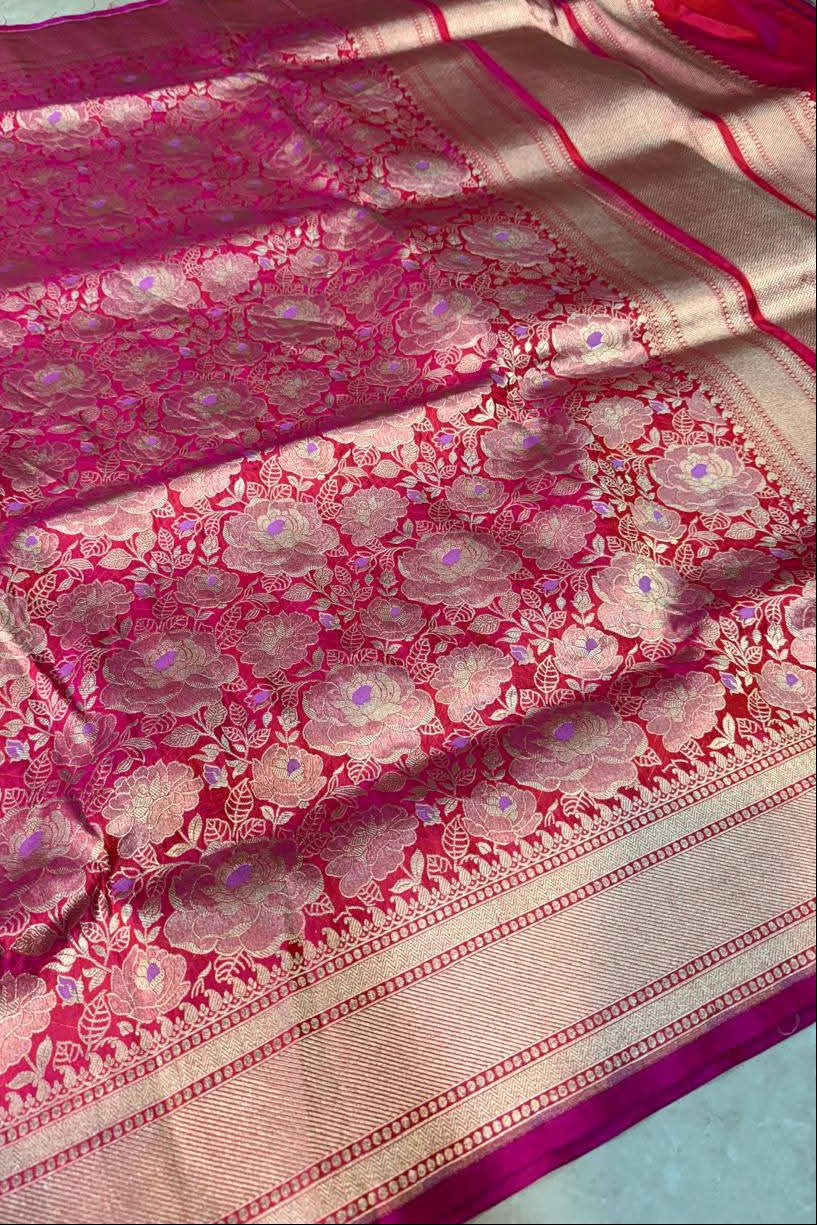 Pink and beige saree with intricate patterns on a light blue background