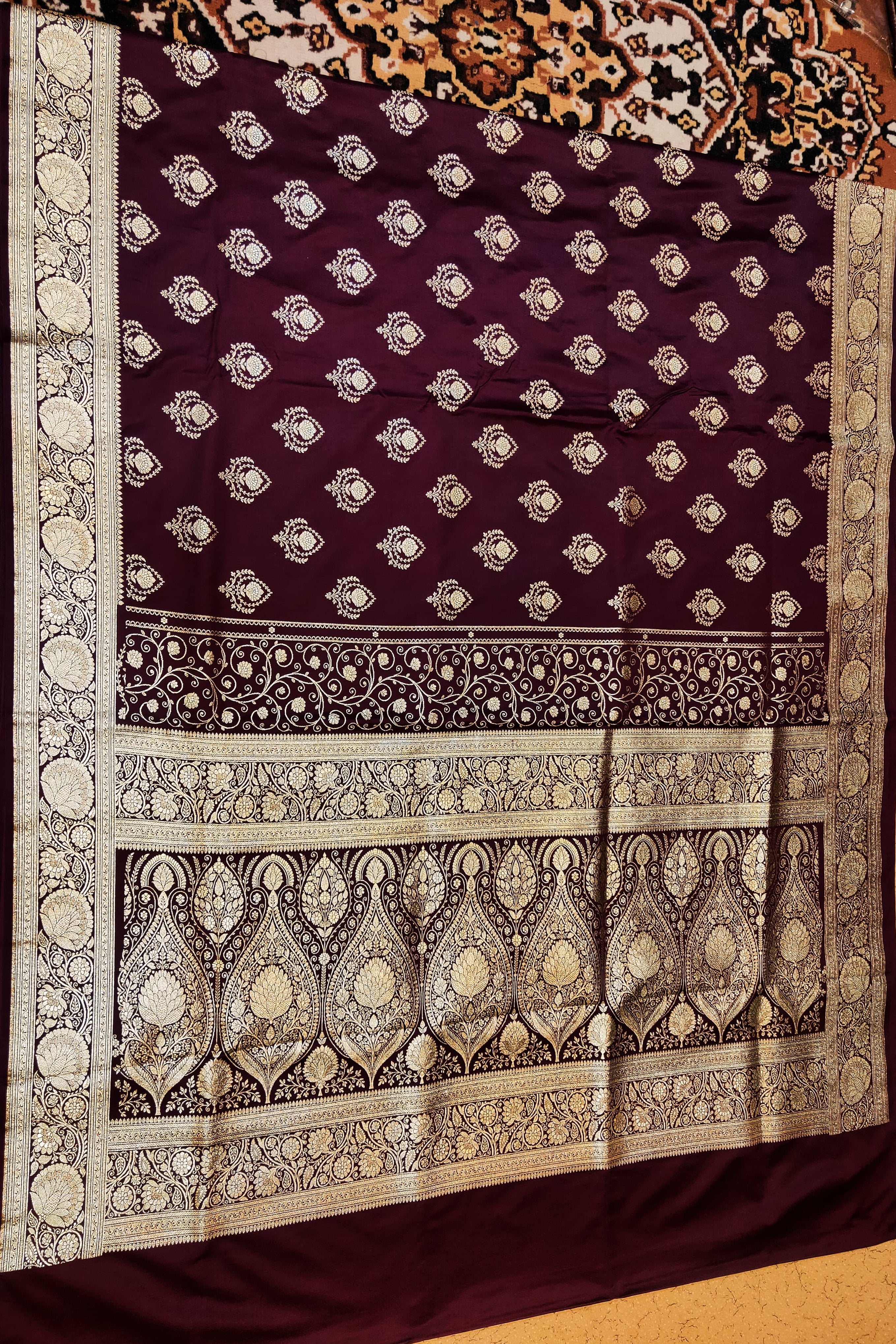 Decorative purple fabric with intricate white patterns on a wooden surface