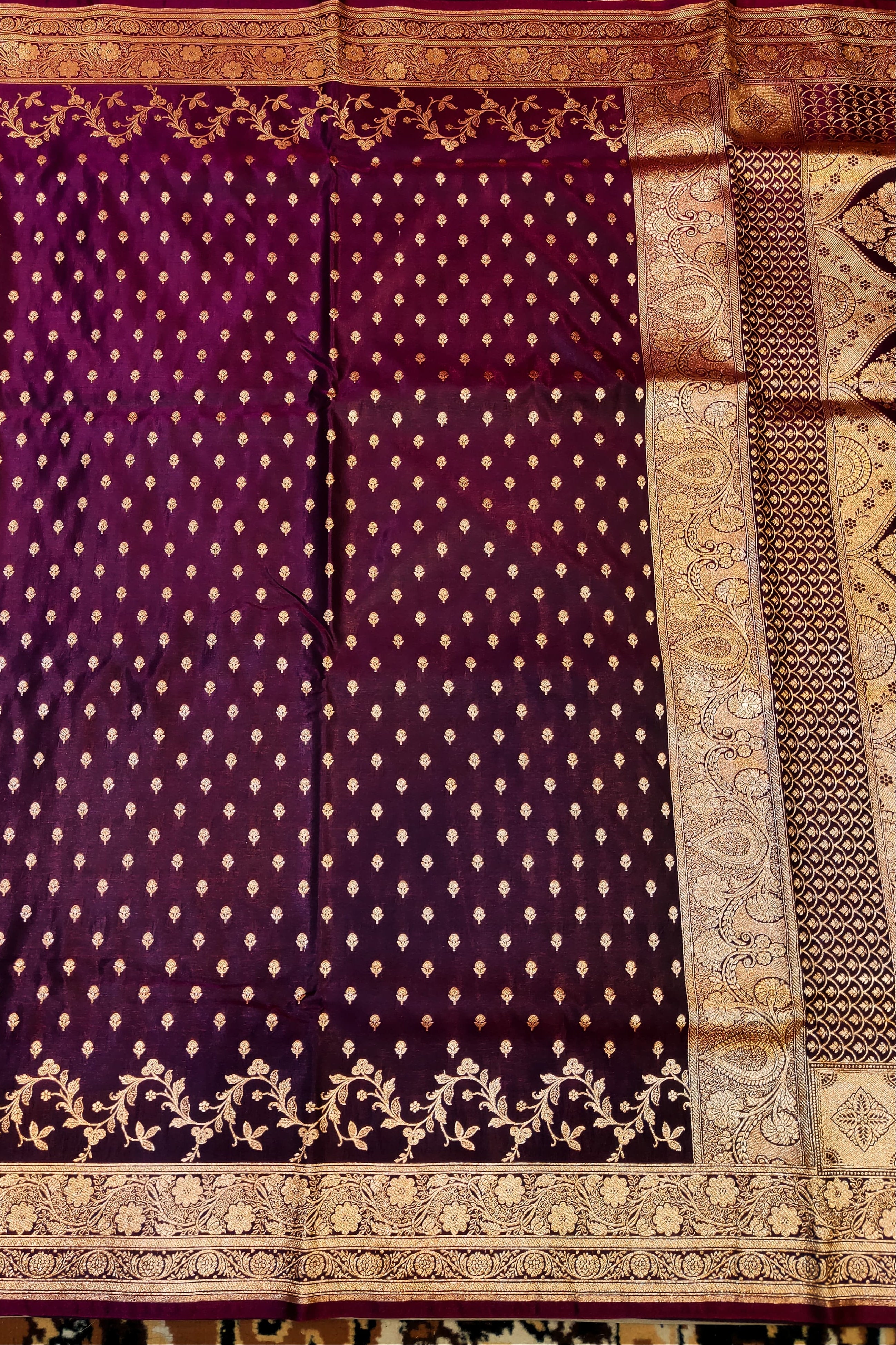 Purple saree with gold patterns on a textured background