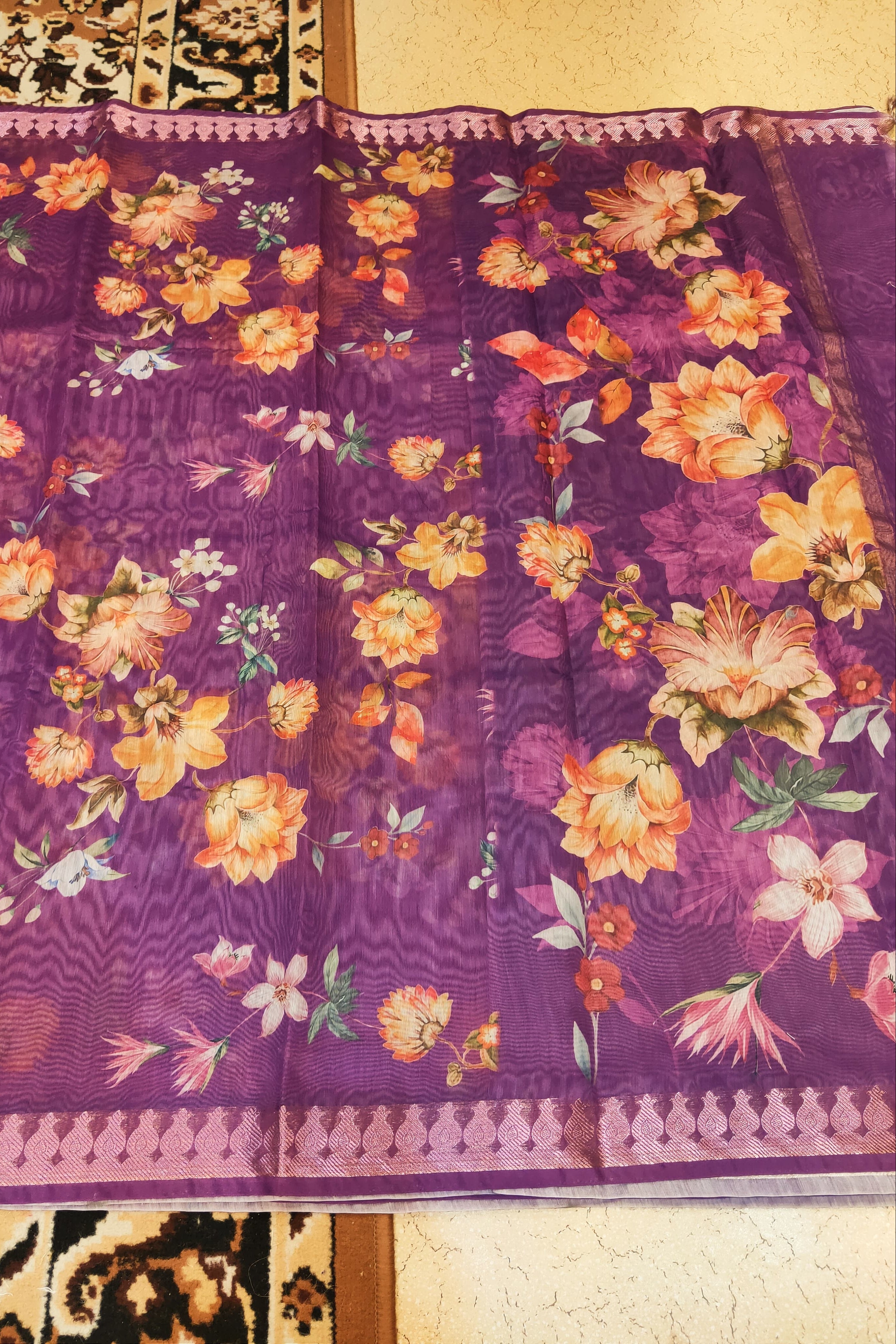 Floral-patterned fabric with a purple background on a textured surface