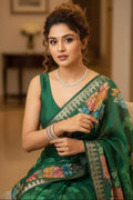 Woman in a green saree with floral patterns indoors