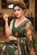 Woman in a green floral saree with jewelry indoors