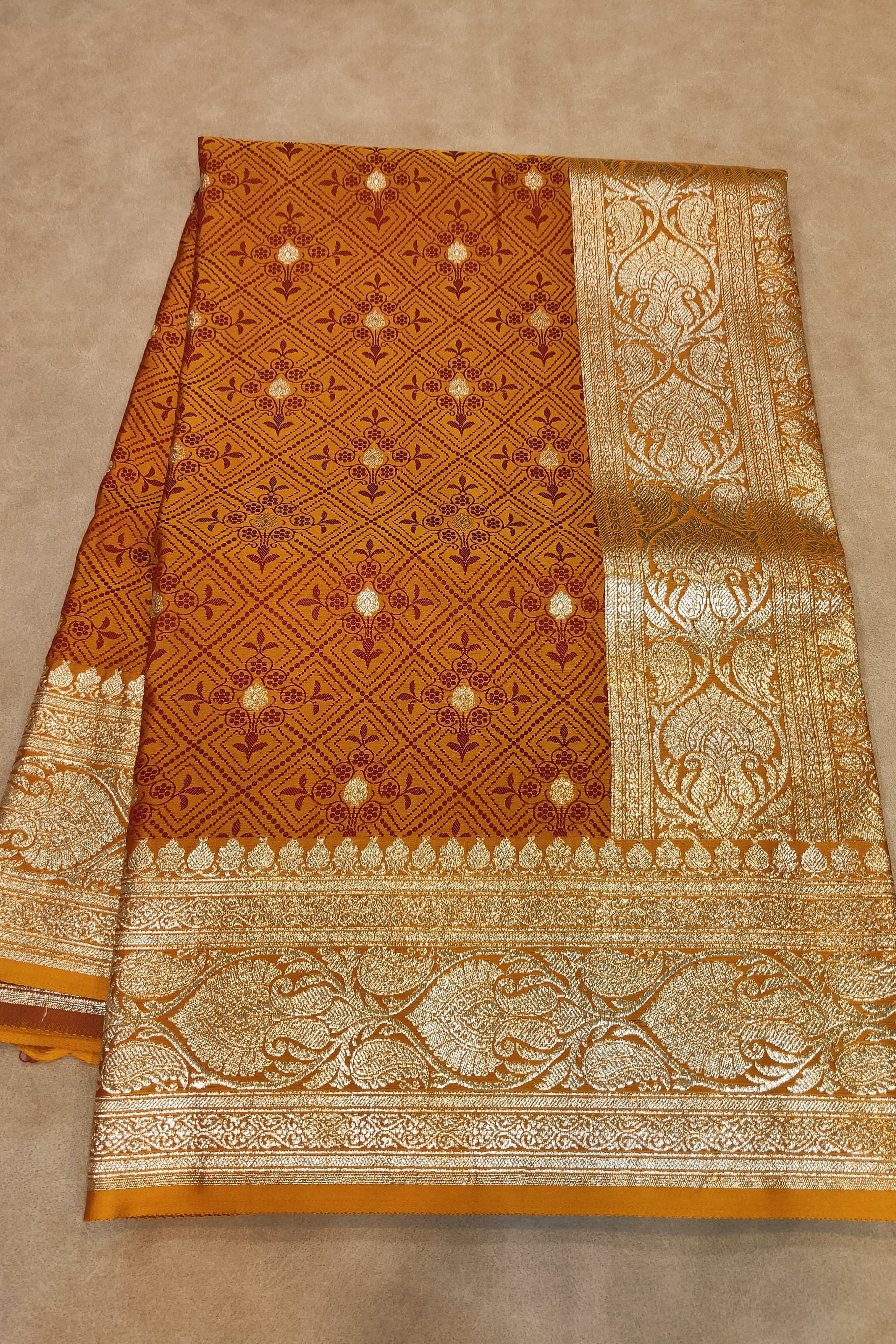 Brown and gold patterned fabric on a beige background