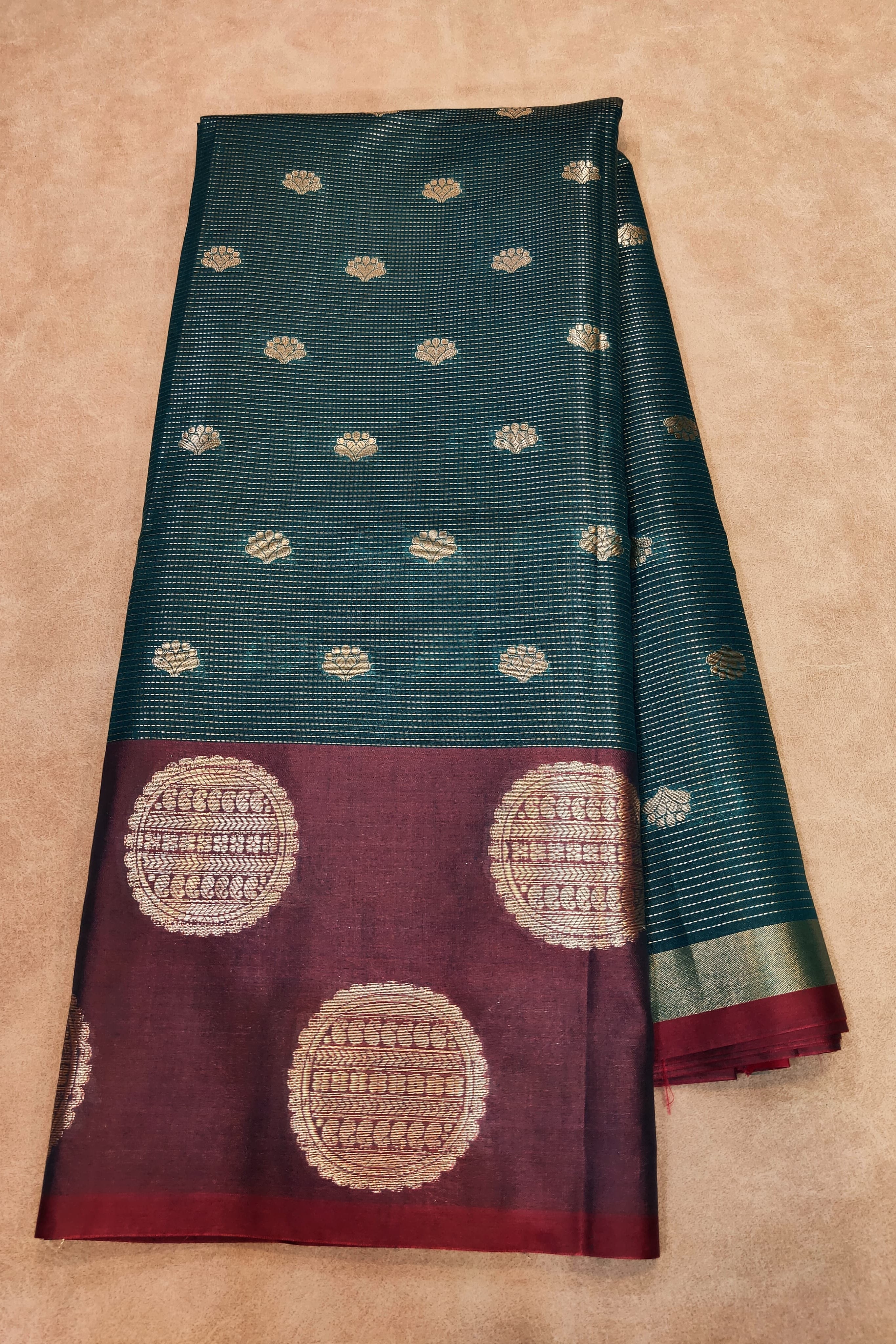 Saree with green and maroon design on a beige background
