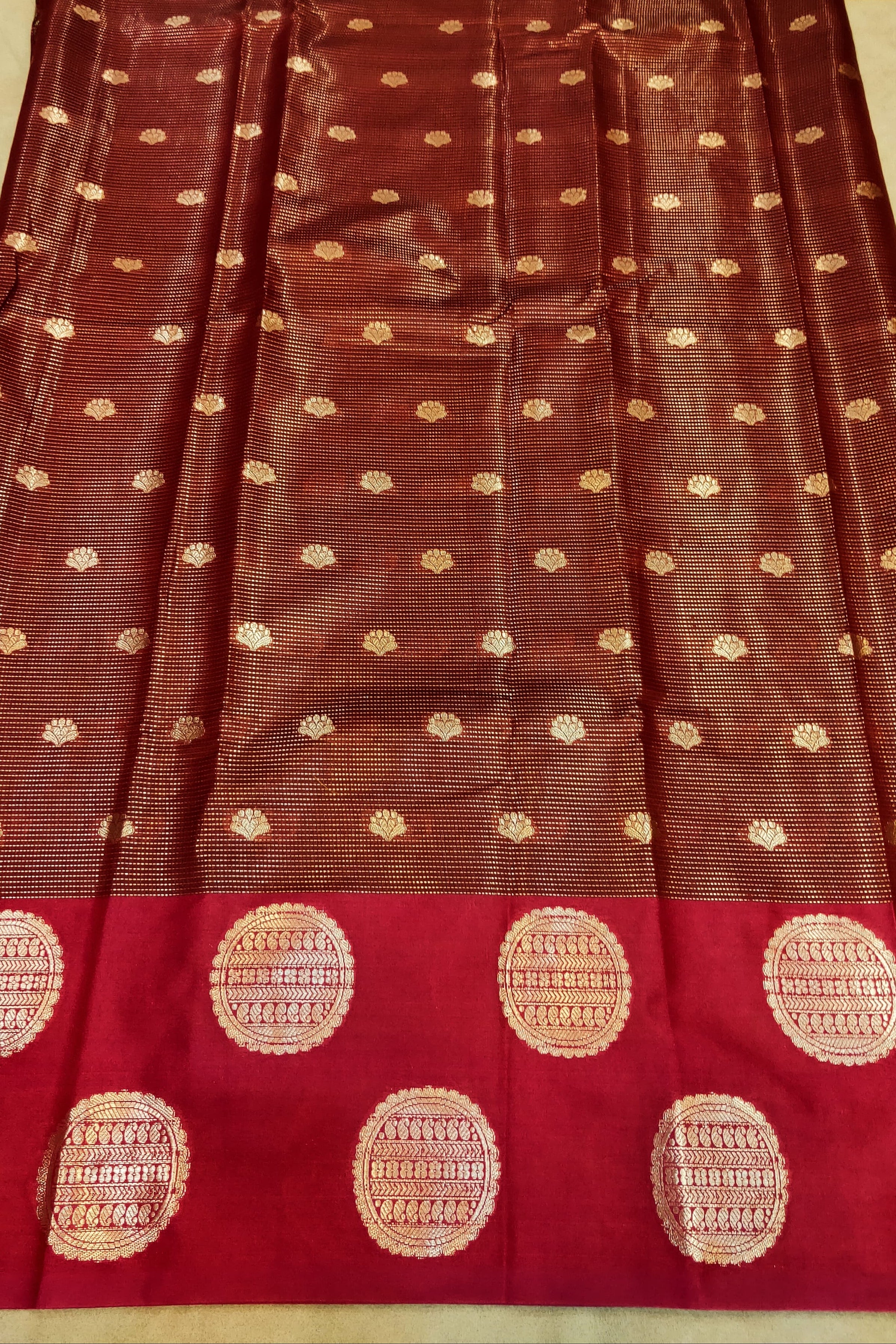 Brown saree with gold patterns on a red border