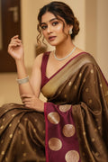 Woman in a traditional brown and gold saree with a blurred background
