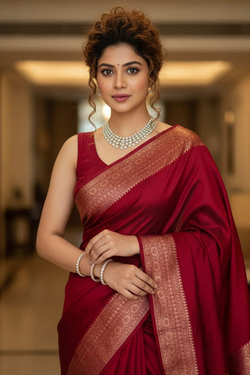 Woman in a red saree with gold border indoors