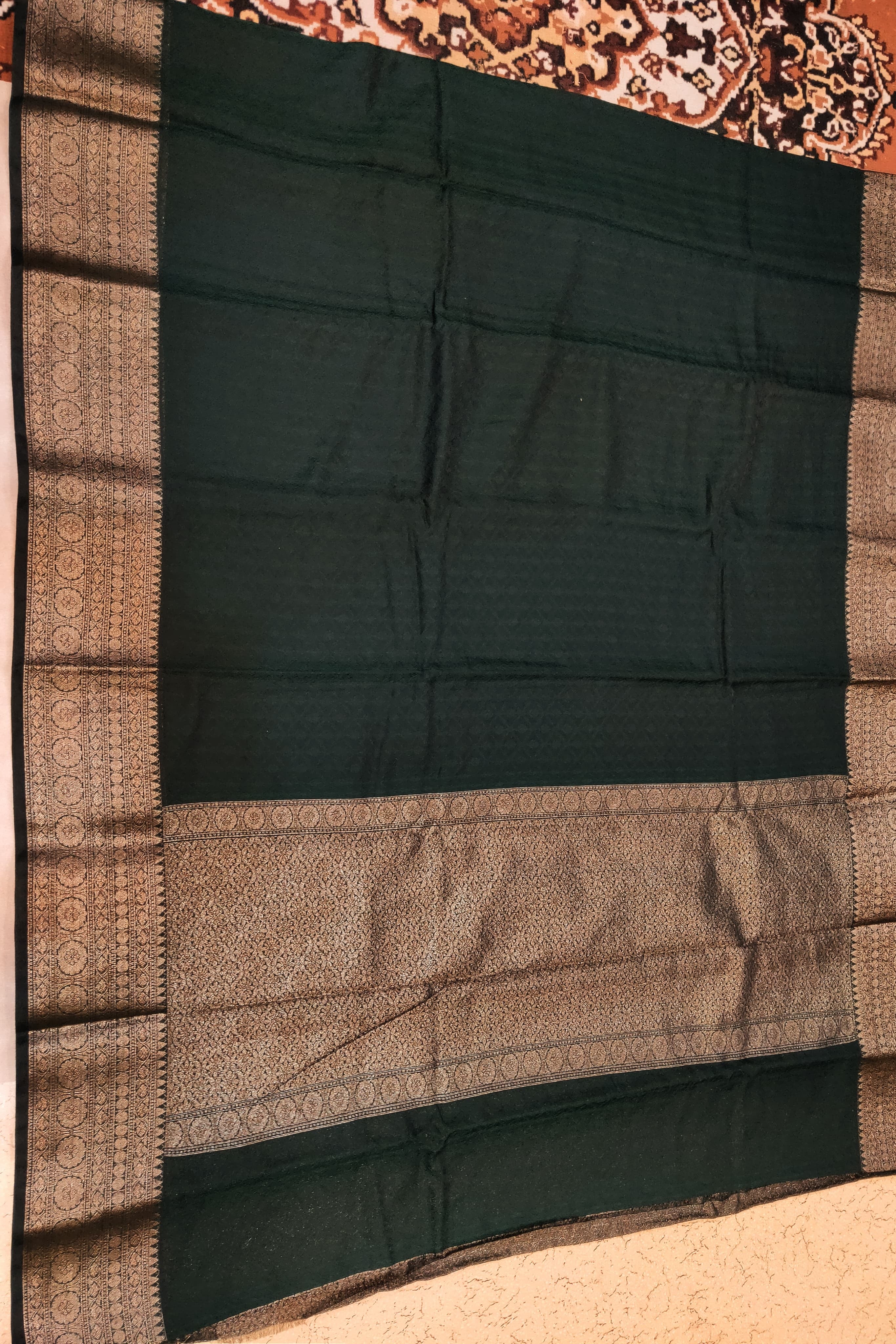 Black and brown patterned fabric draped over a surface with a decorative background.