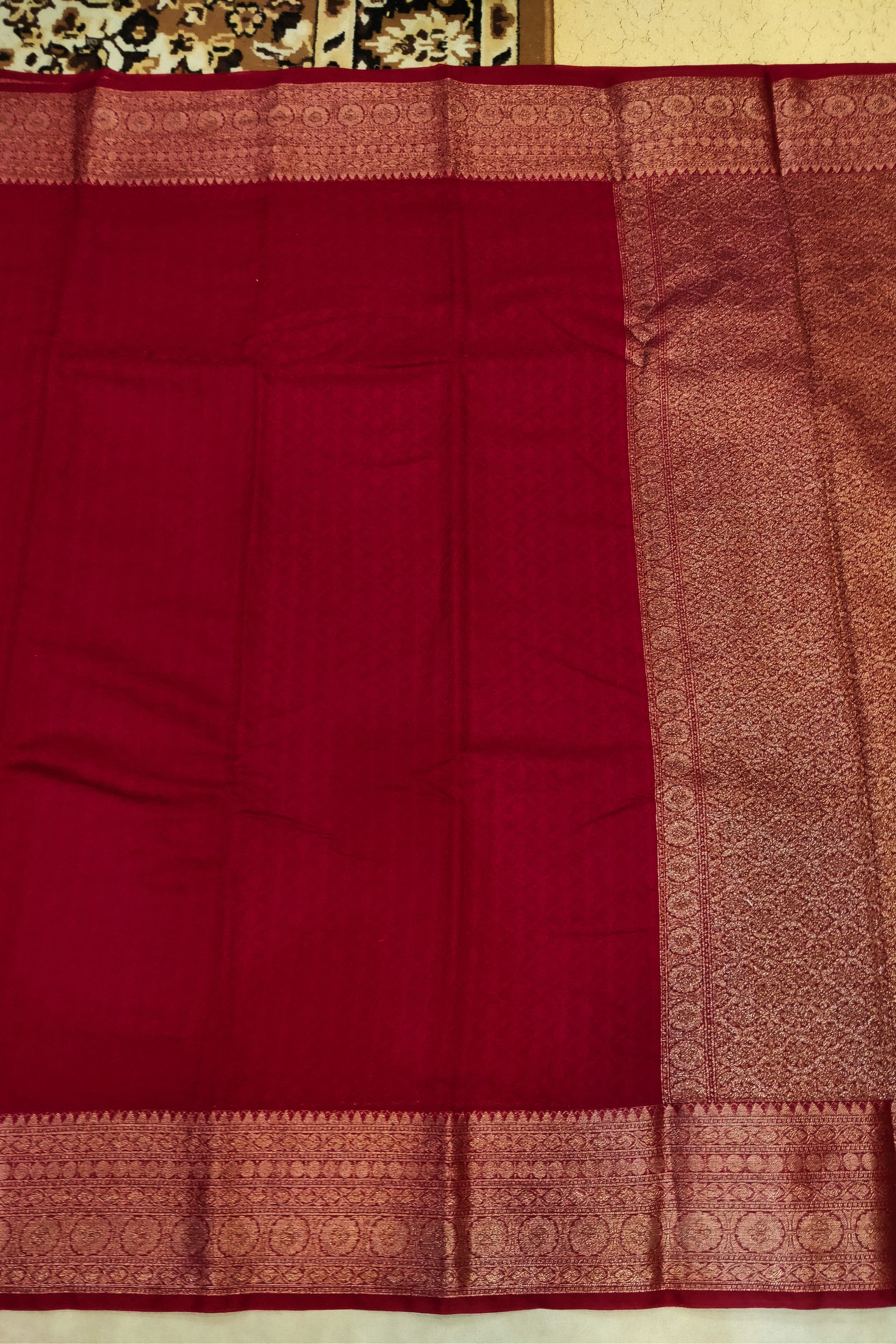 Red fabric with gold border on a plain background