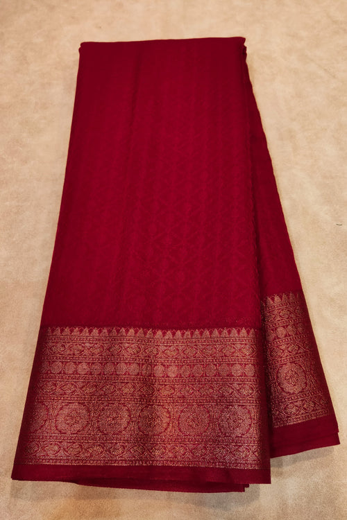 Red fabric with a patterned border on a beige background
