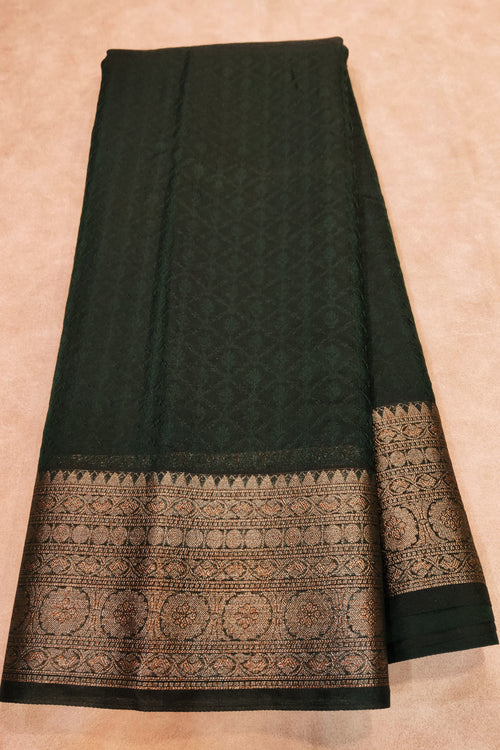 Black saree with intricate gold patterns on a beige background