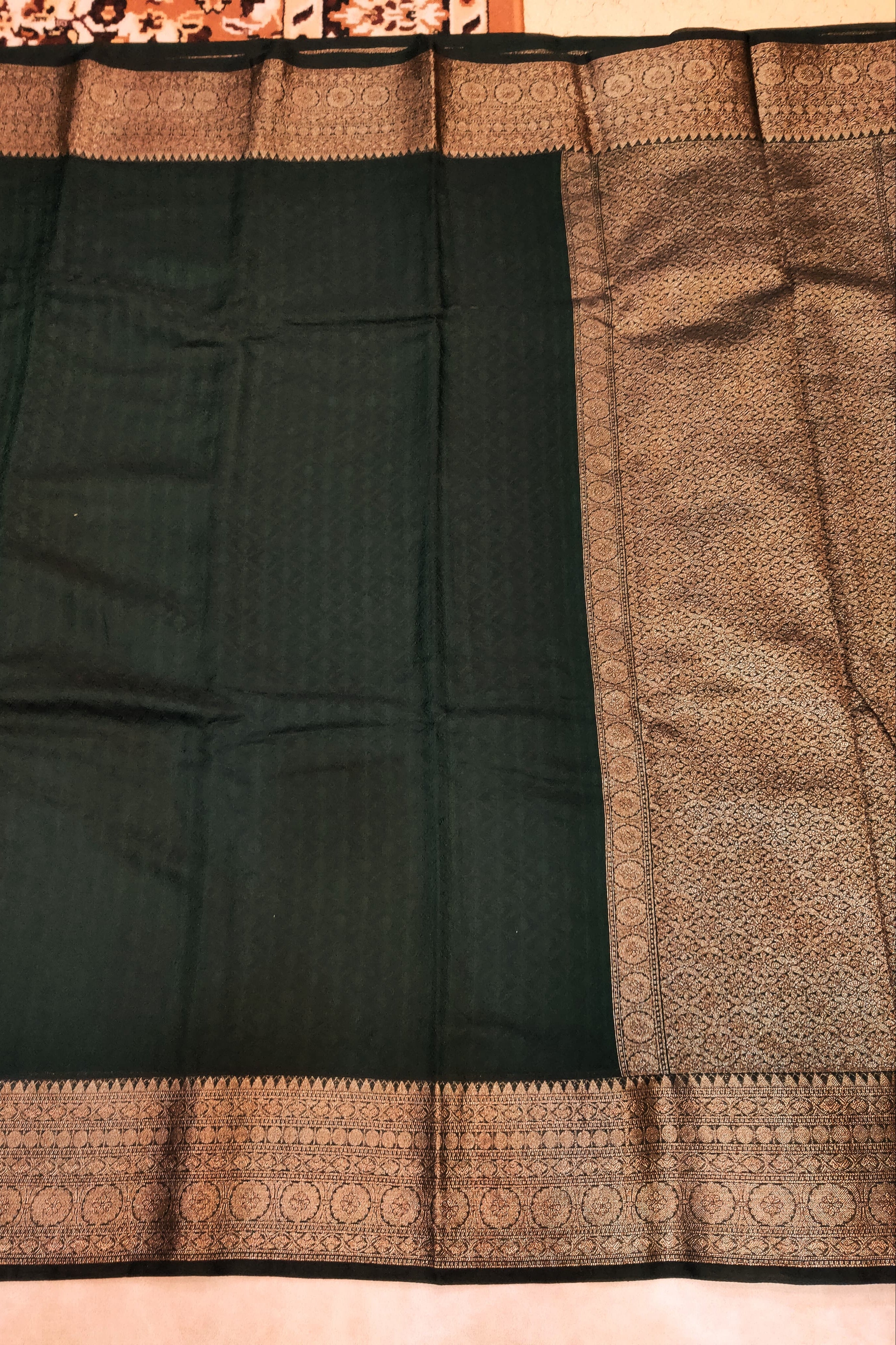 Black saree with brown border on a plain background