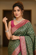 Woman wearing a green and pink saree with jewelry indoors
