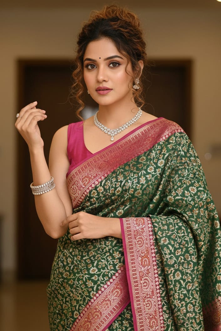 Woman wearing a green and pink saree with jewelry indoors