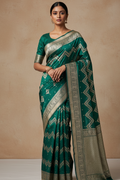 Woman wearing a green saree with a beige background