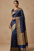 Woman wearing a blue and gold saree with a plain background