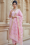 Woman in a pink traditional outfit standing in front of an architectural background