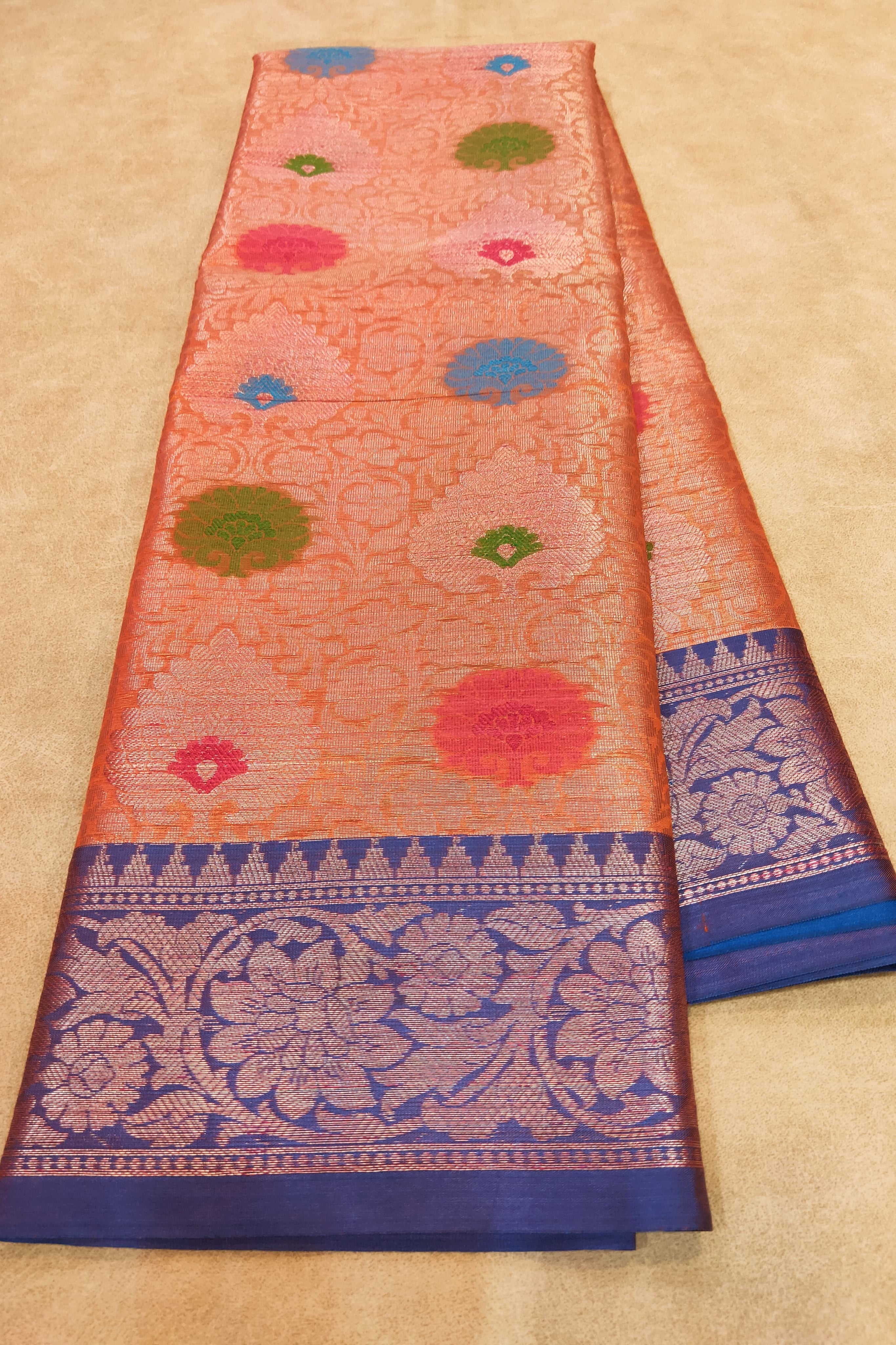 Saree with floral patterns and a blue border on a beige background