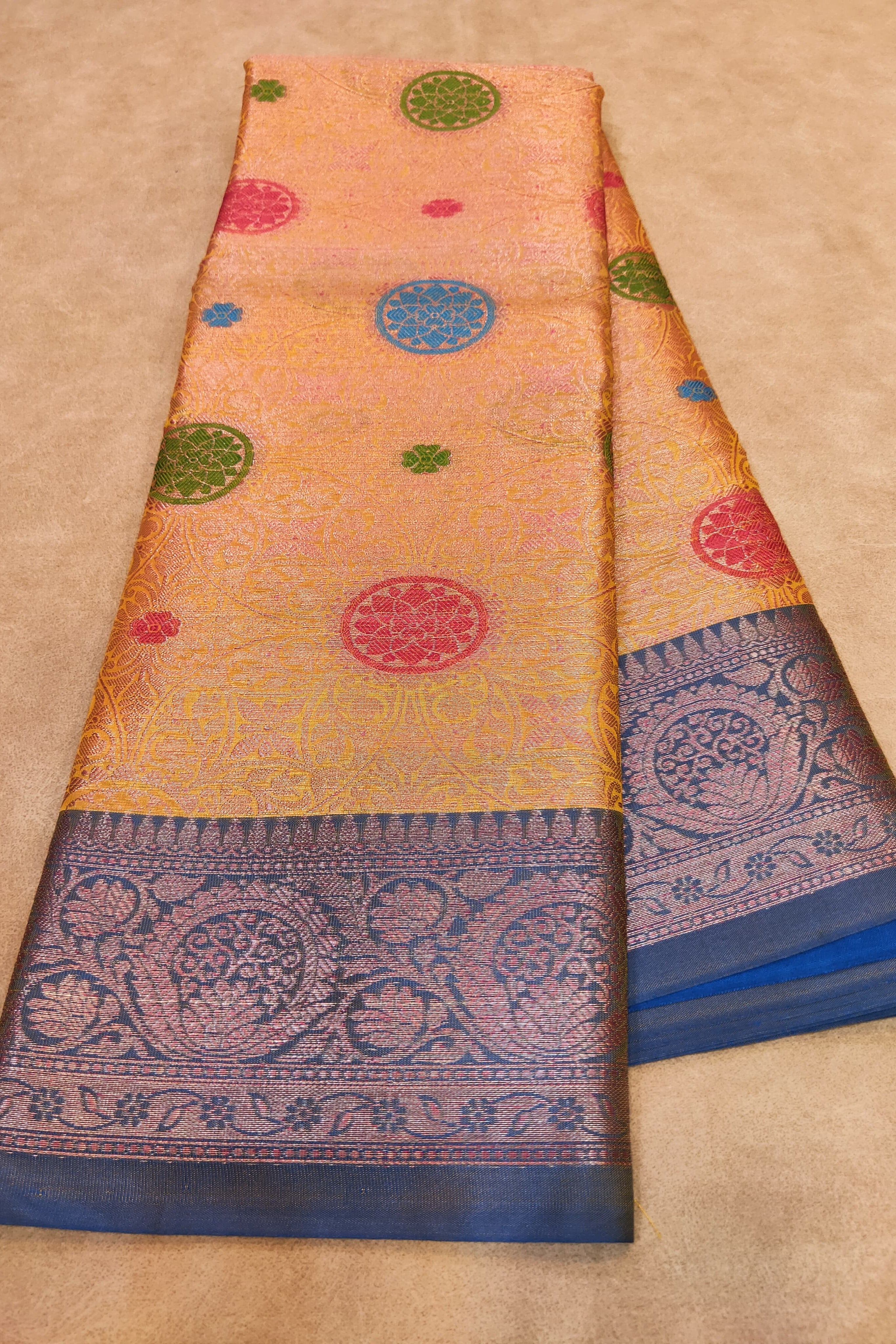 Traditional saree with colorful patterns on a beige background