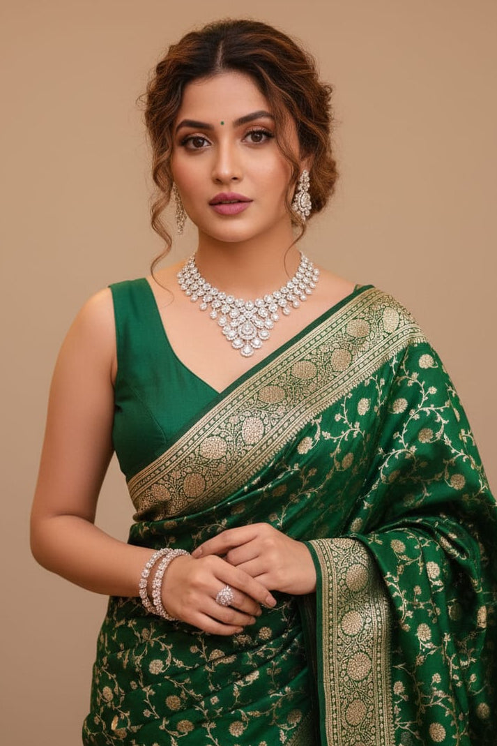 Woman wearing a green saree with gold patterns on a beige background
